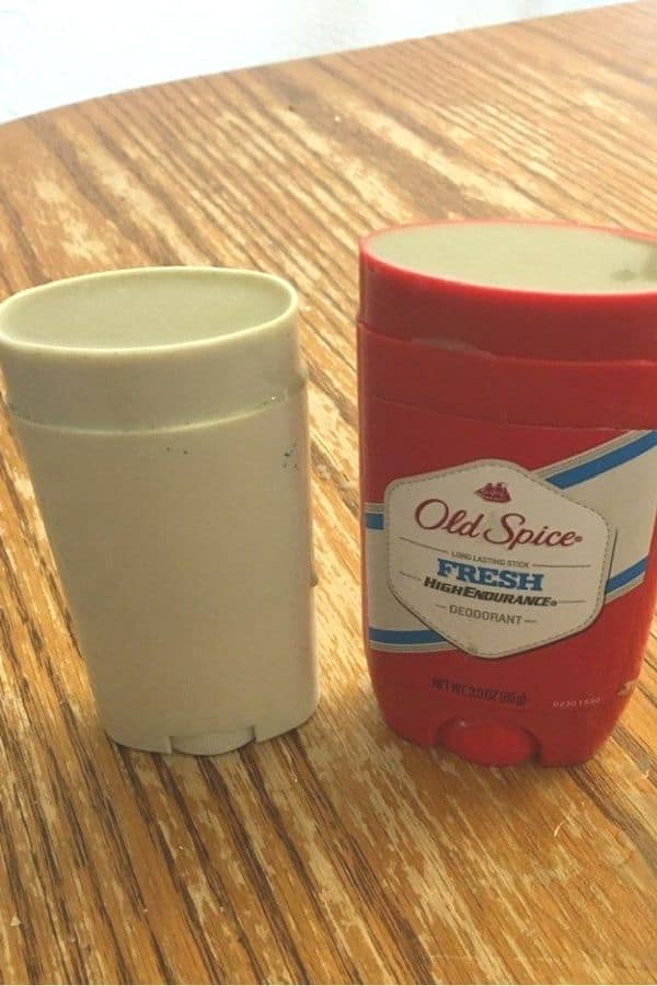 Two Homemade DIY Deodorant in stick deodorant canisters on a wood surface.