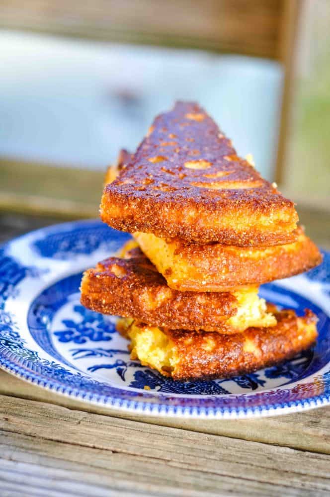 best cornbread recipe slices stacked on a blue willow plate.