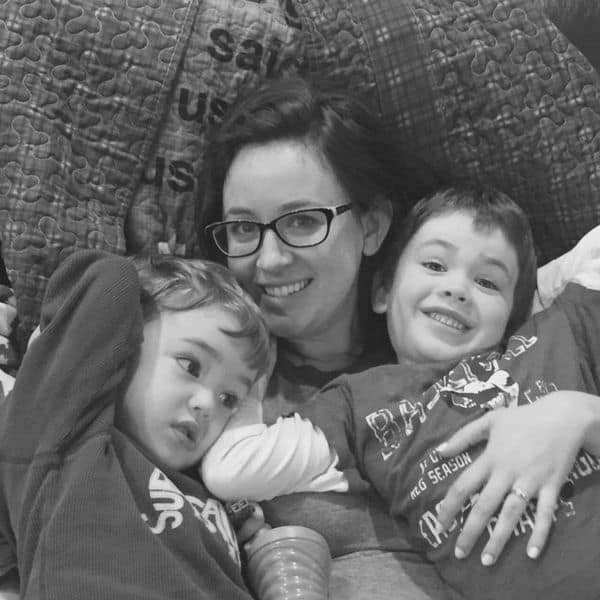 Christian mom with two little boys in a chair, cuddling.