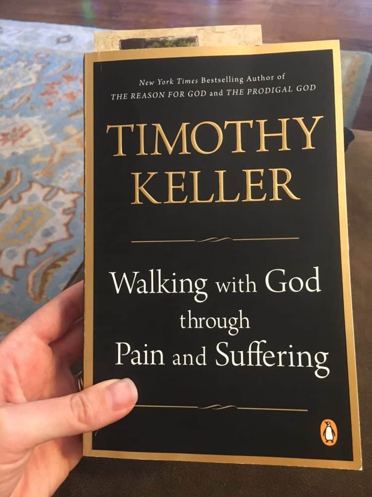 Person holding a book on spiritual maturity entitled, "Walking with God through Pain and Suffering"