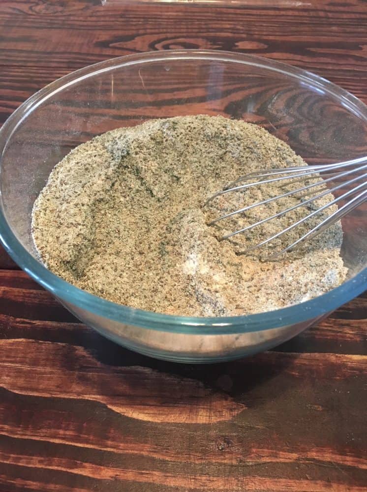 Completed smoothie powder combined in a large glass bowl with a whisk.