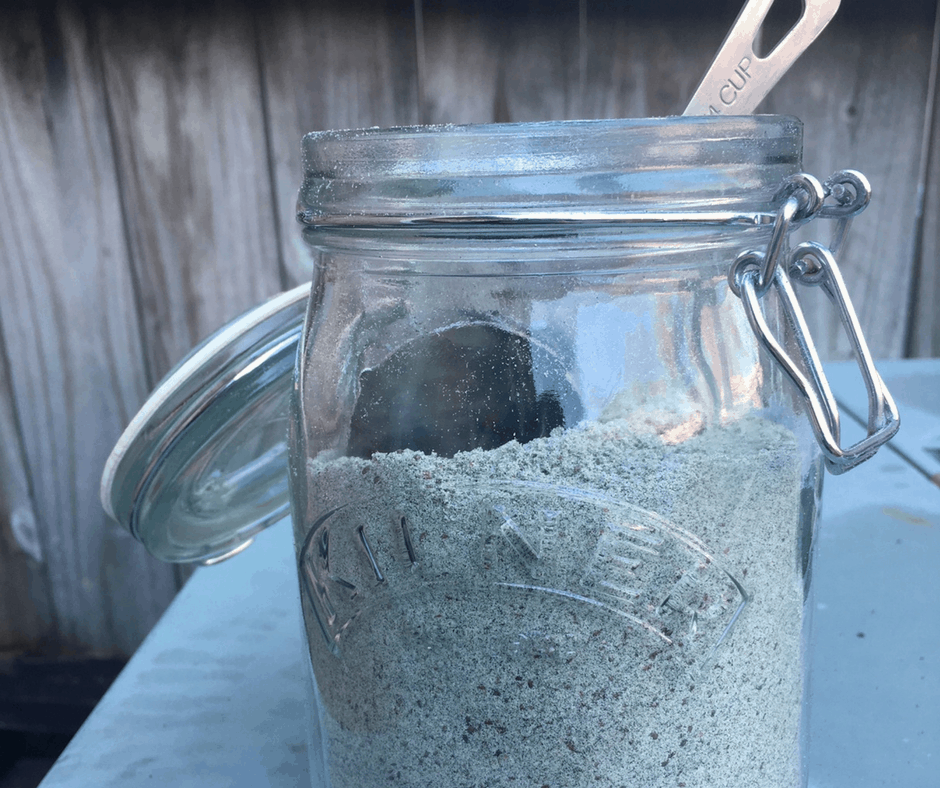 Superfood powders for smoothies in a large jar with a scoop.