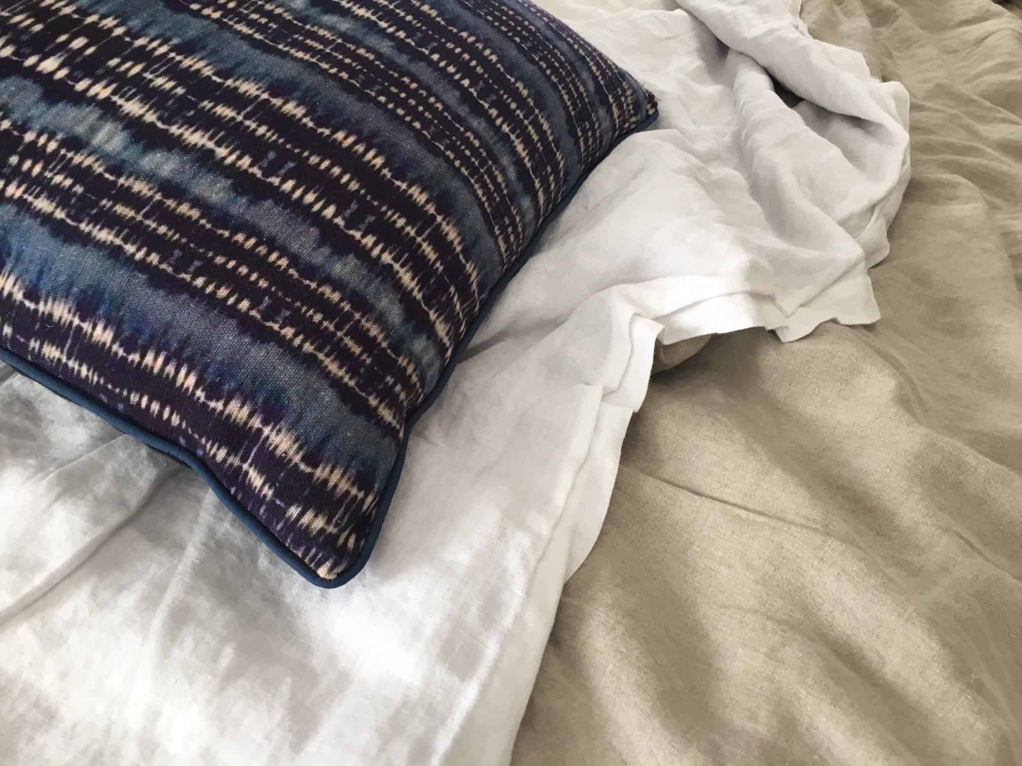 Close-up decorative pillow and linen bedding.