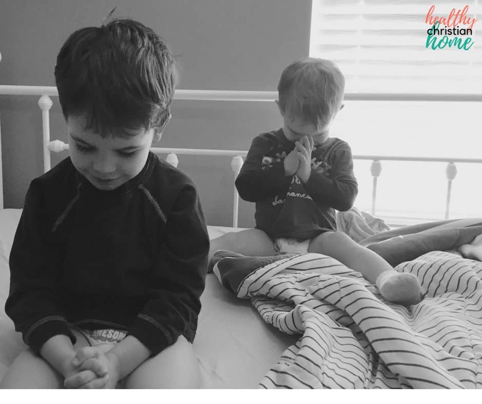 Black and white photo of two little boys praying.