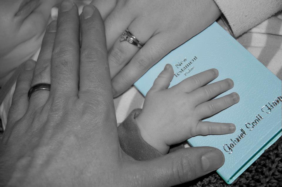 Bible verses about mothers - a mother, father, and baby's hands all on top of a bible.