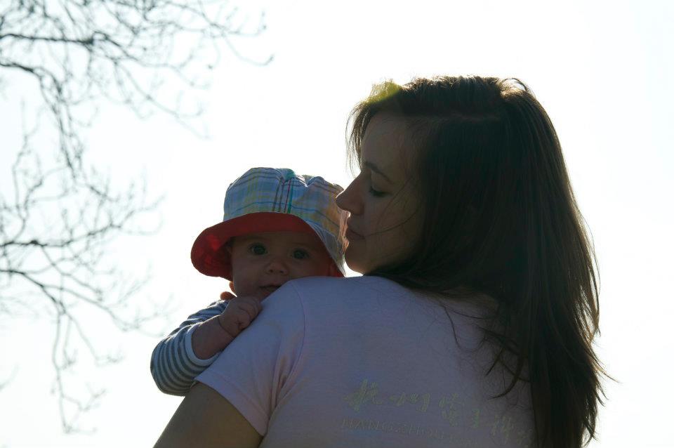 Bible verses about mothers - a mom in profile holding her baby in a floppy hat.