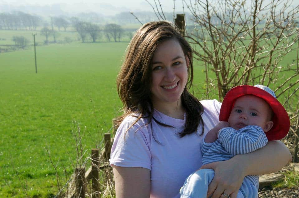 Bible verses about mothers - mom holding a baby on a sunny morning in a green field.