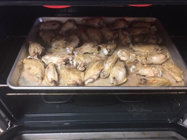 Baking frozen wings on a sheet pan in a hot oven.