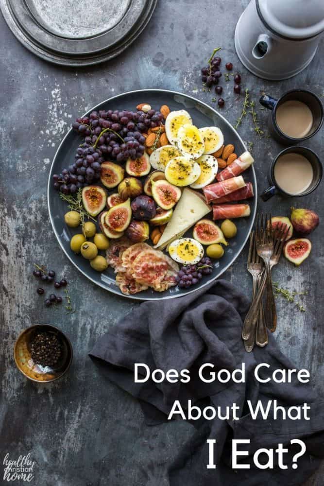 A bowl of healthy food including figs, fruit, cheese, and eggs on a dark table with cutlery and napkins.