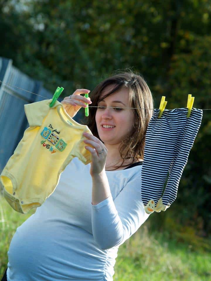 Woman hanging baby clothes on a clothes line
