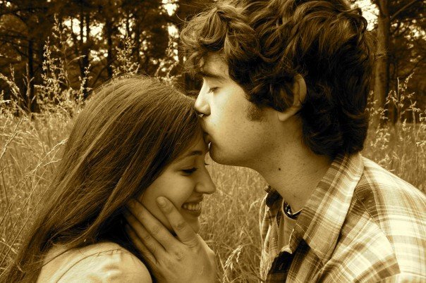 Husband kissing wife on the forehead.