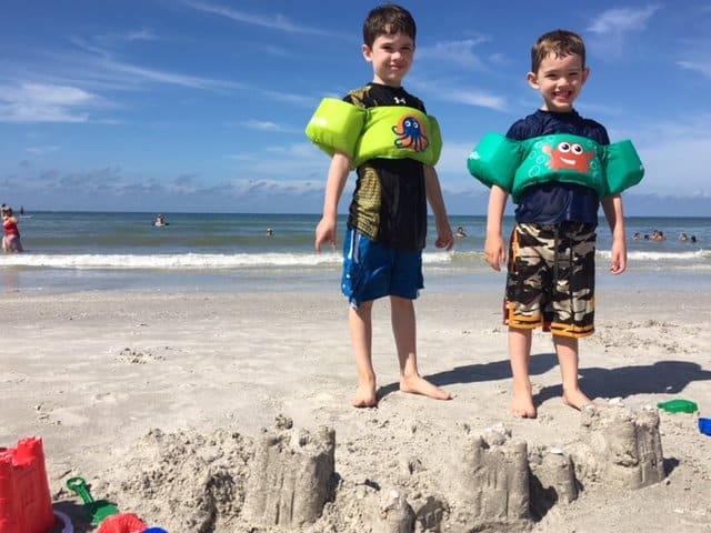 Two brothers building sandcastles at the beach