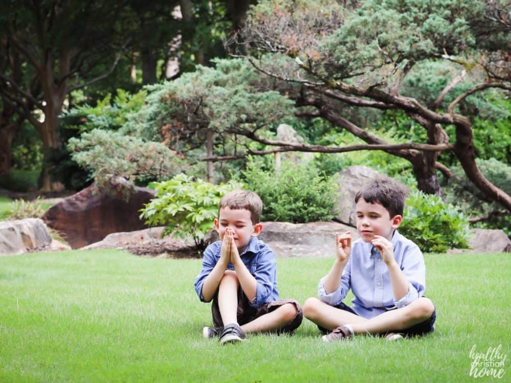 Children saying kids prayers outside.