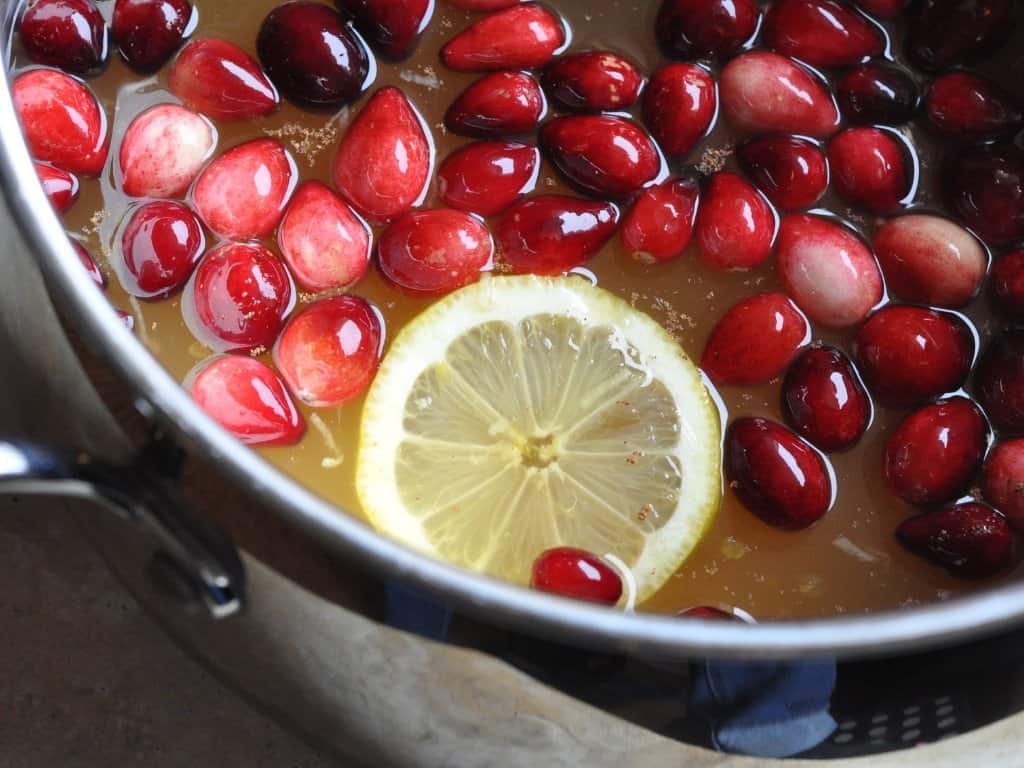 Cranberry wassail ingredients in a pot on the stove.