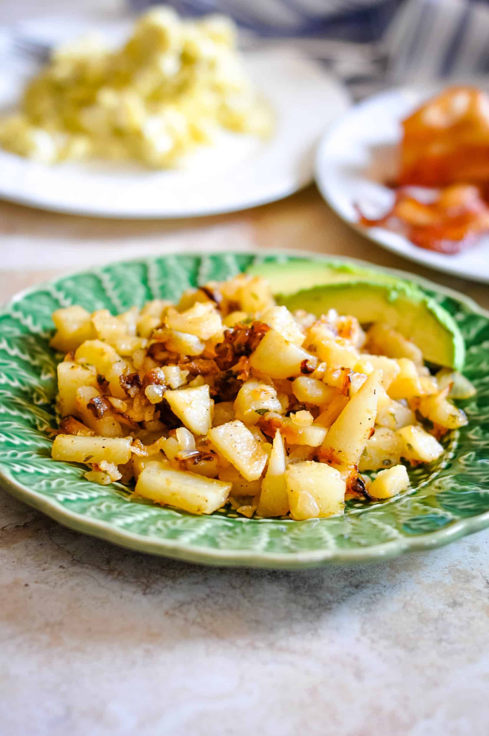 Home fried potatoes on a green decorative plate.