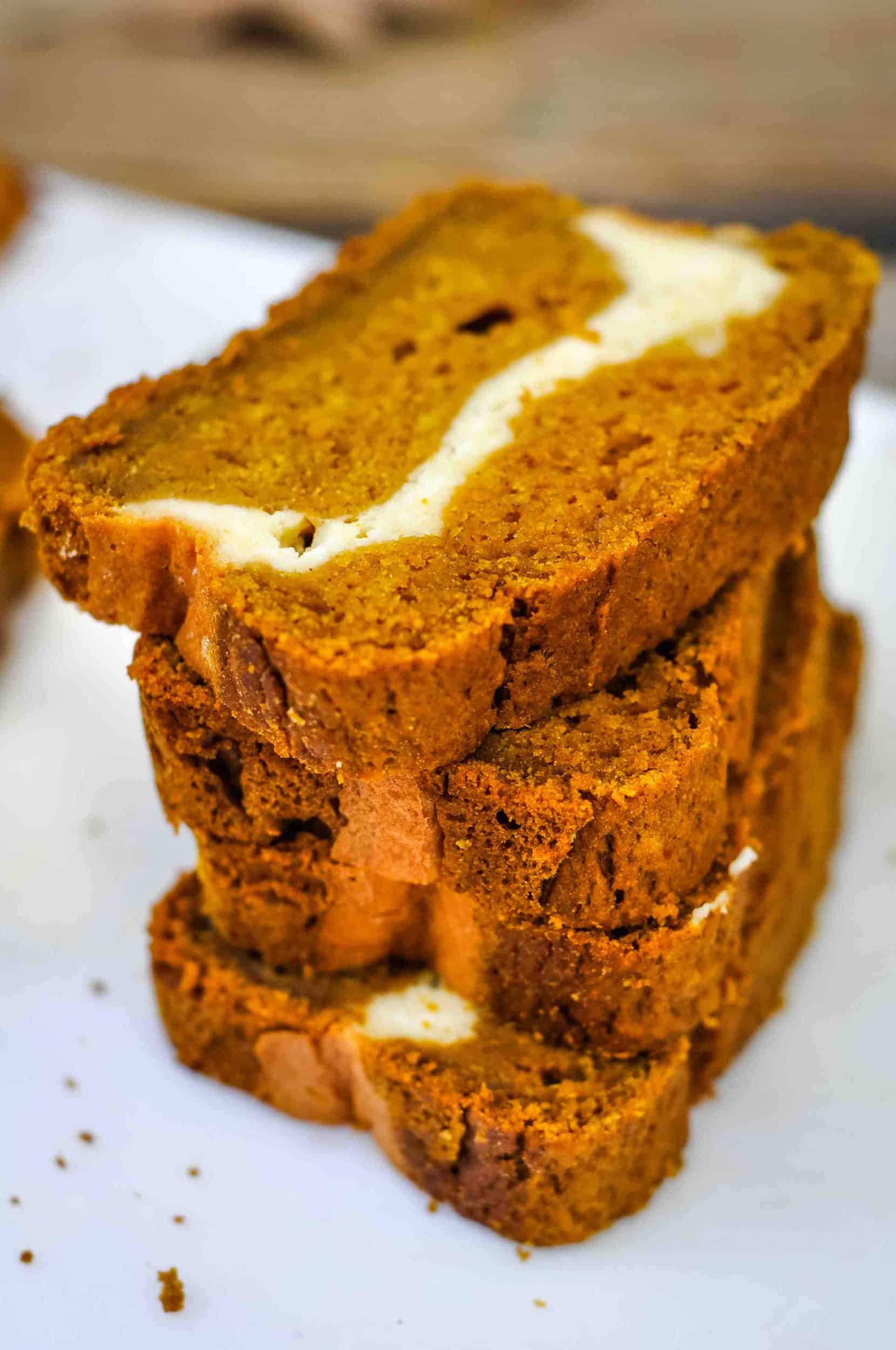 Four slices of pumpkin cream cheese bread stacked up.