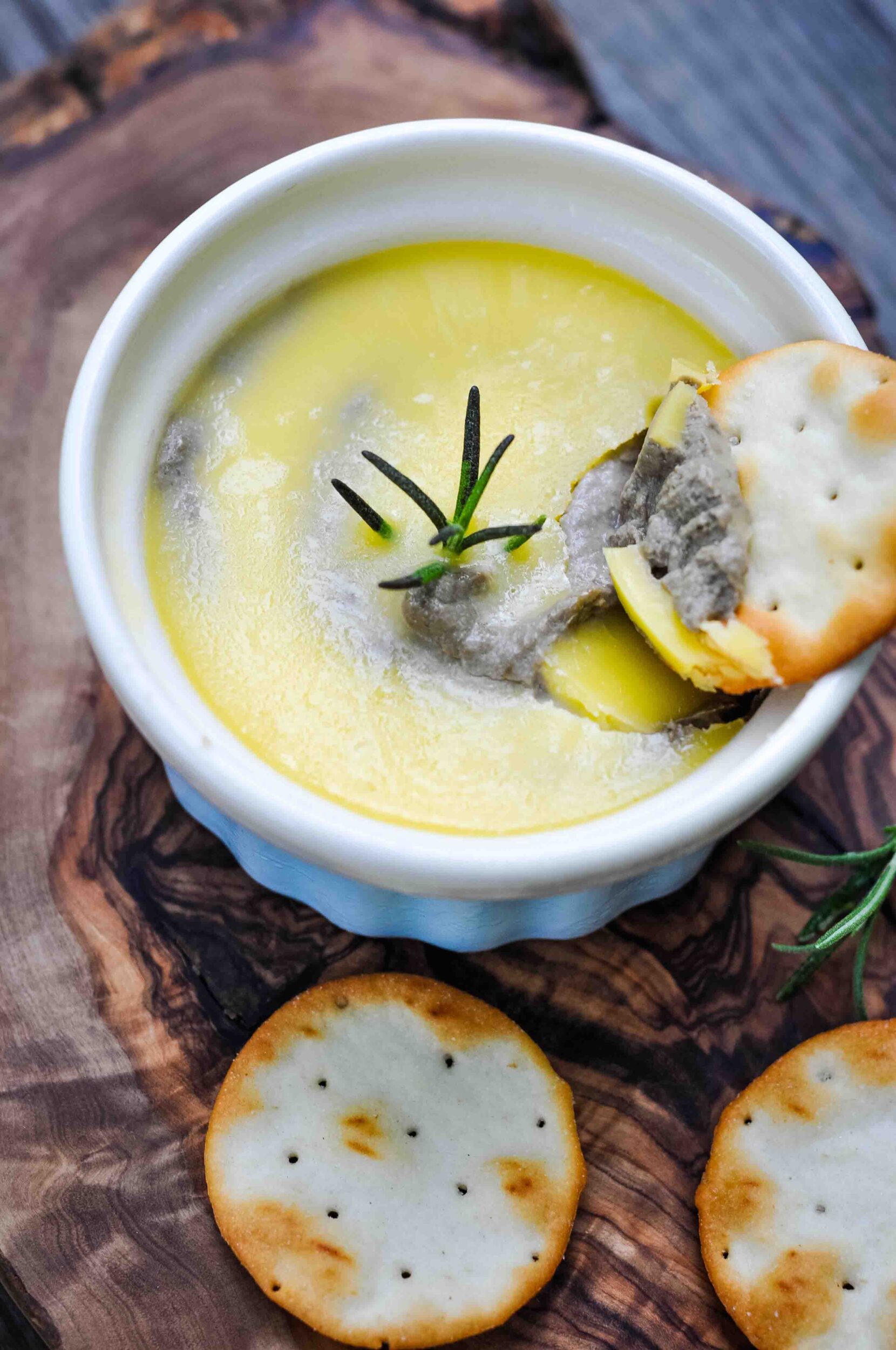 Chicken liver pate in a small bowl with crackers.