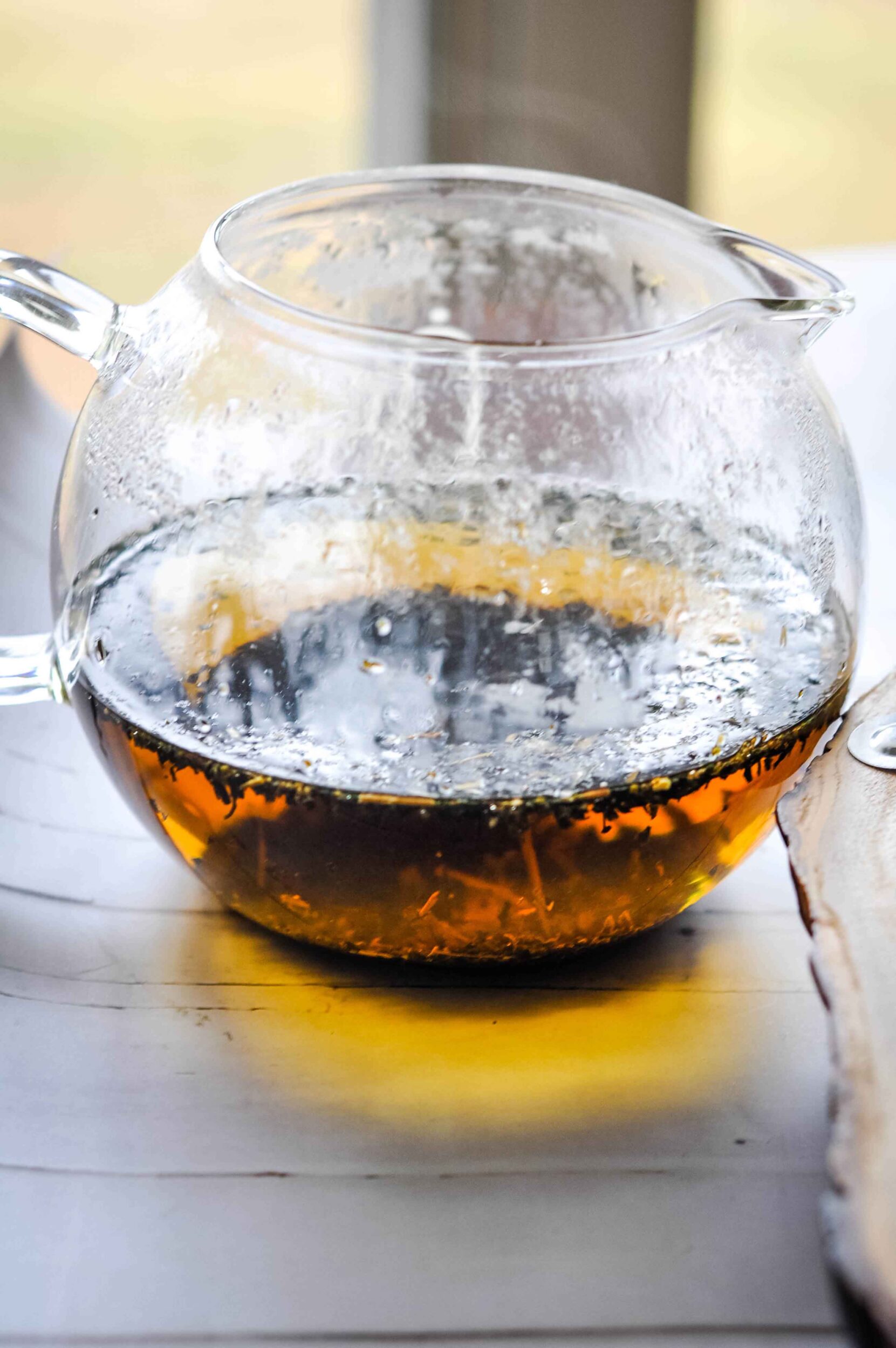 Stinging nettle tea in a cup on a wooden table.