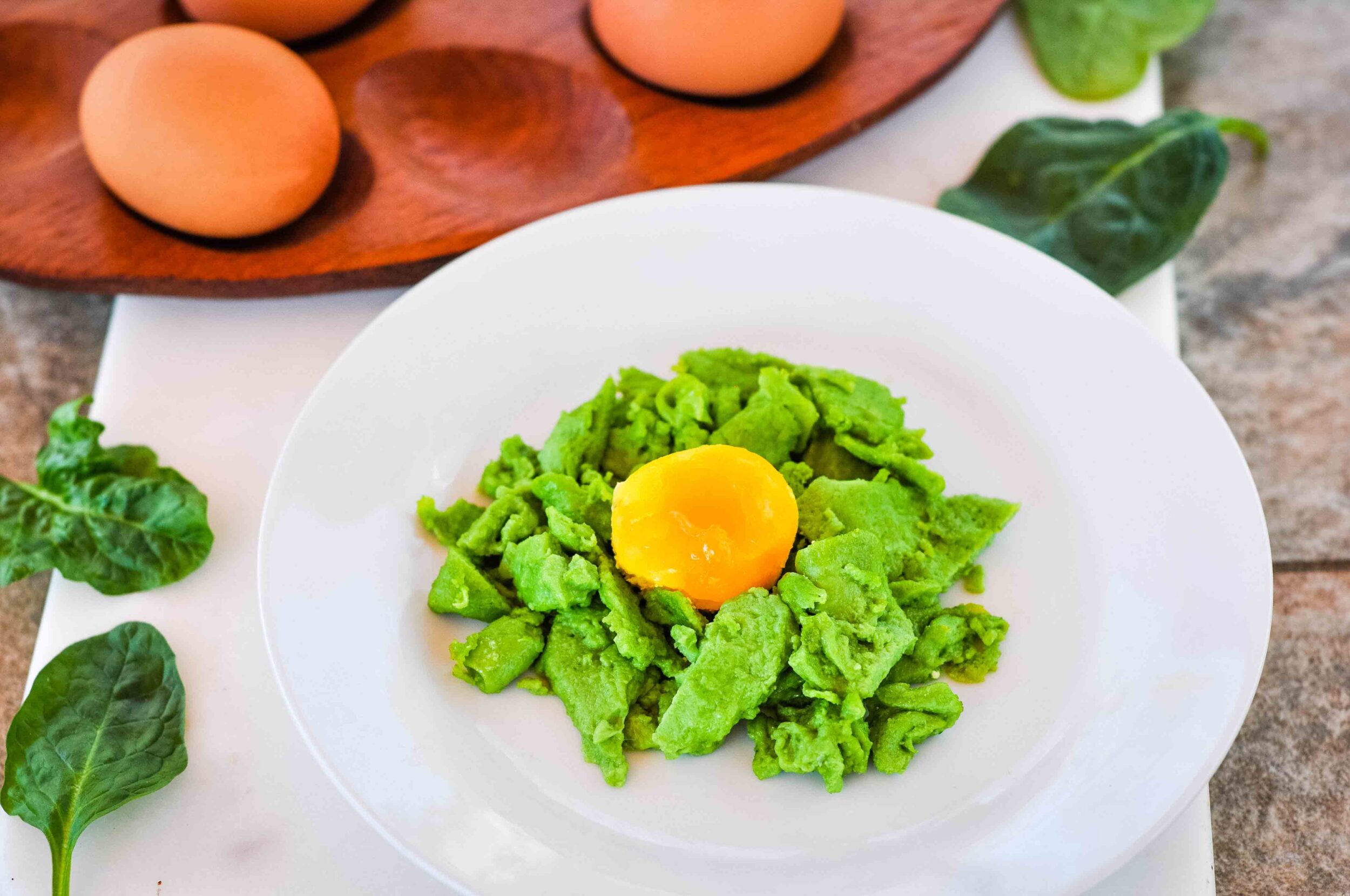 Spinach green eggs with a baked yolk on top.