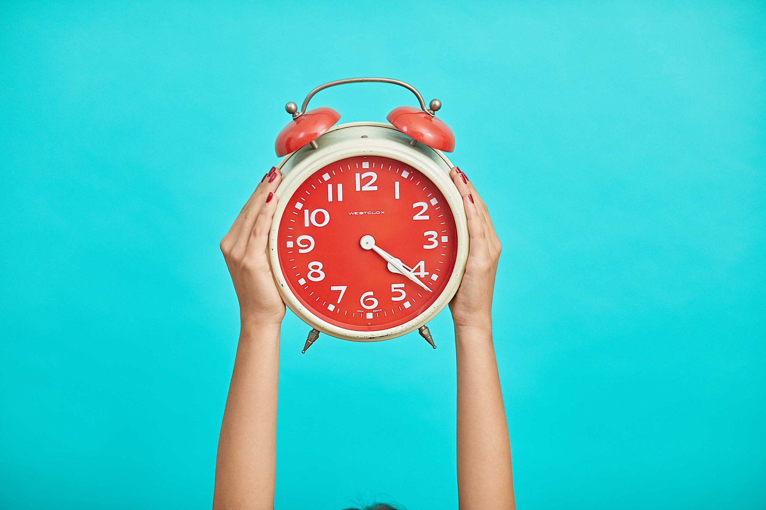 A person holding a clock.