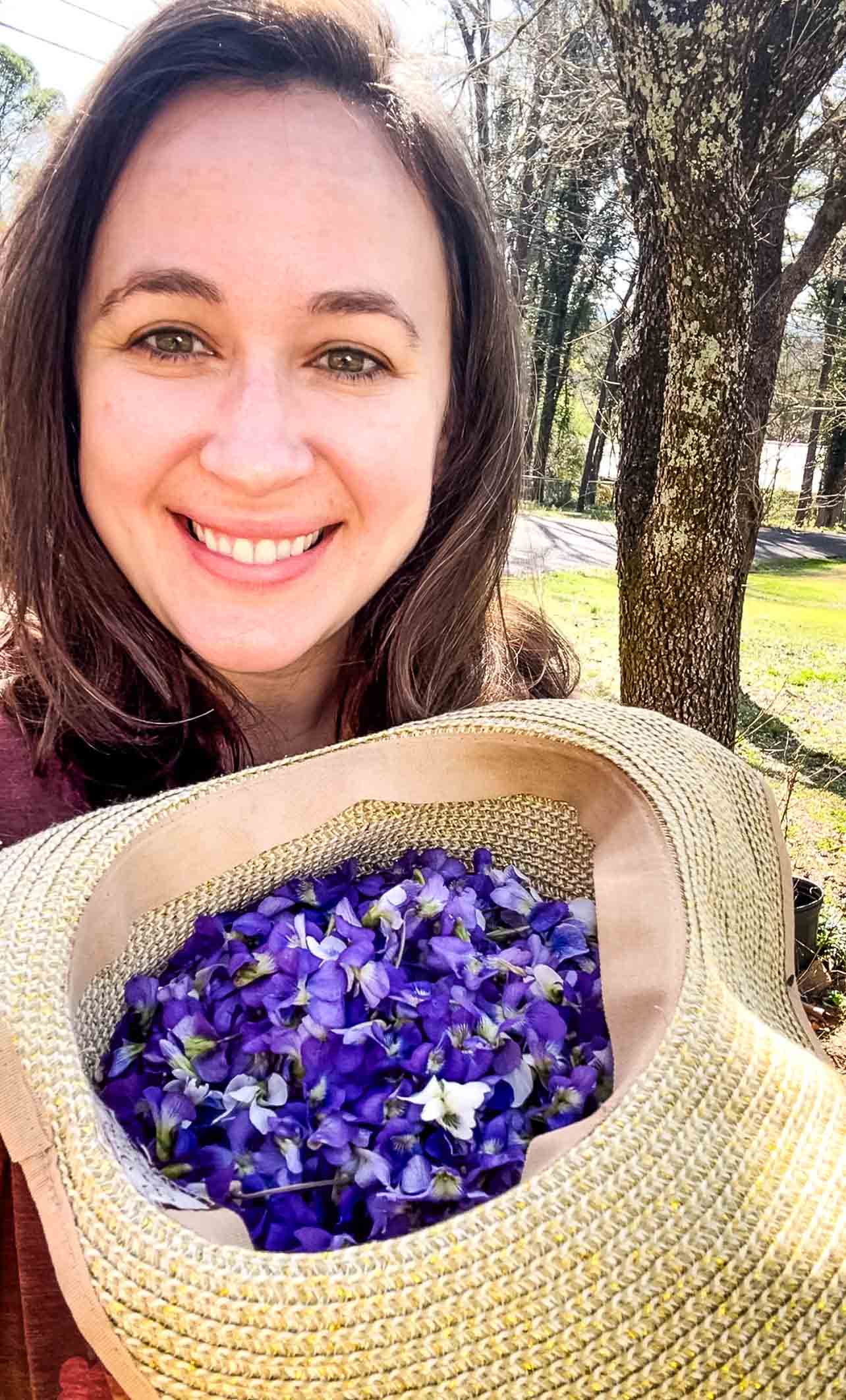 Woman foraging wild violets to make violet vinegar.