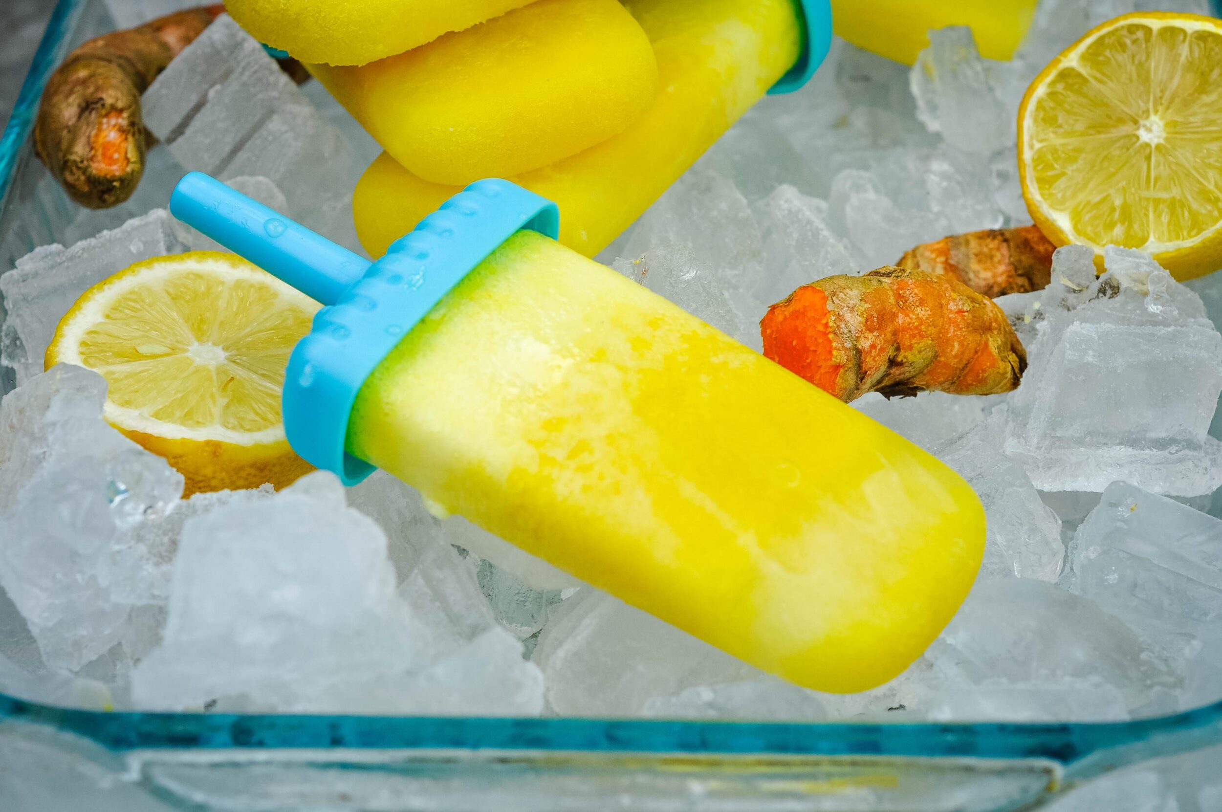 Close up photo of a yellow pineapple popsicle in a dish.