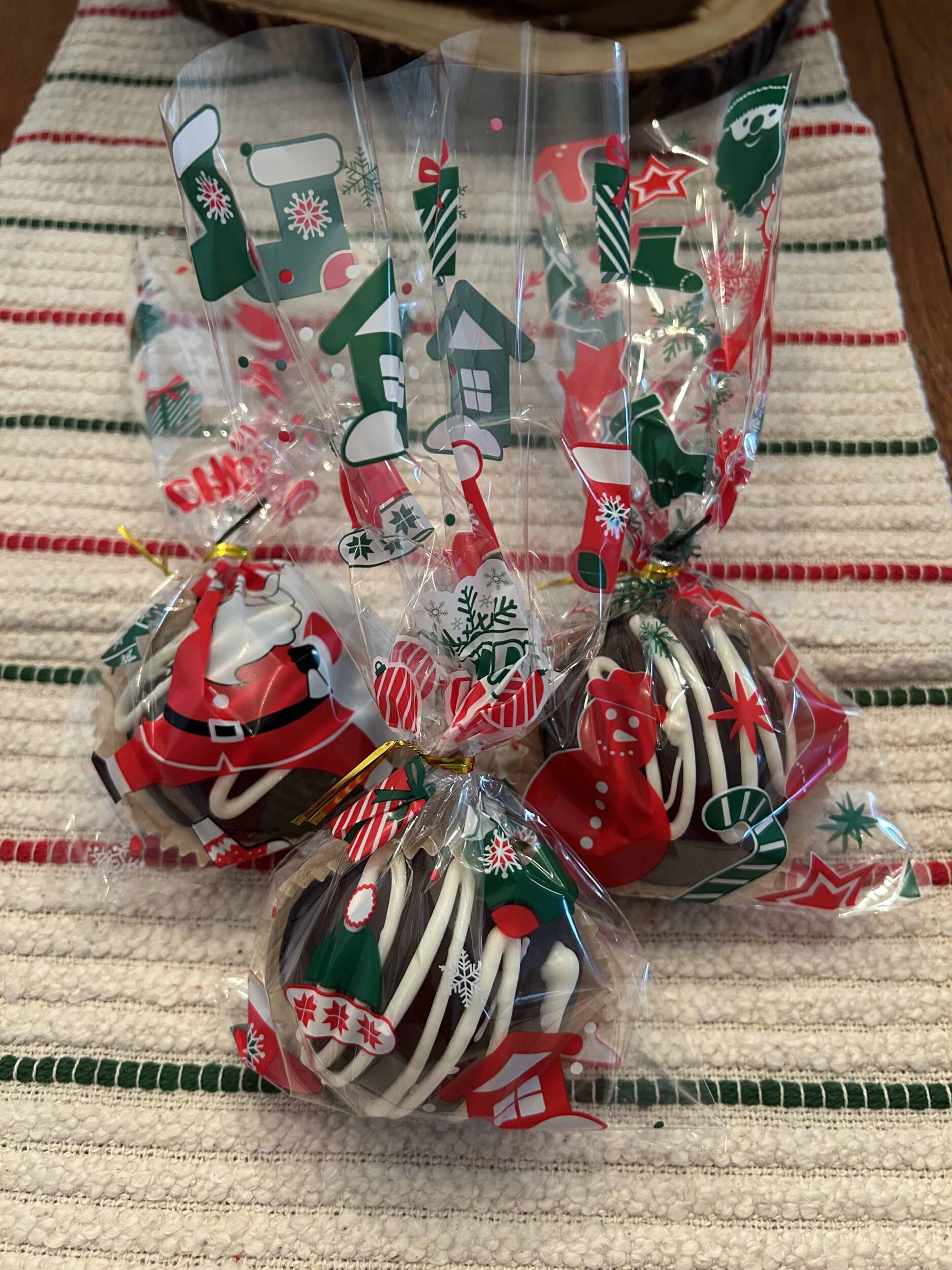 Hot chocolate bombs wrapped in festive holiday clear bags for gifting.