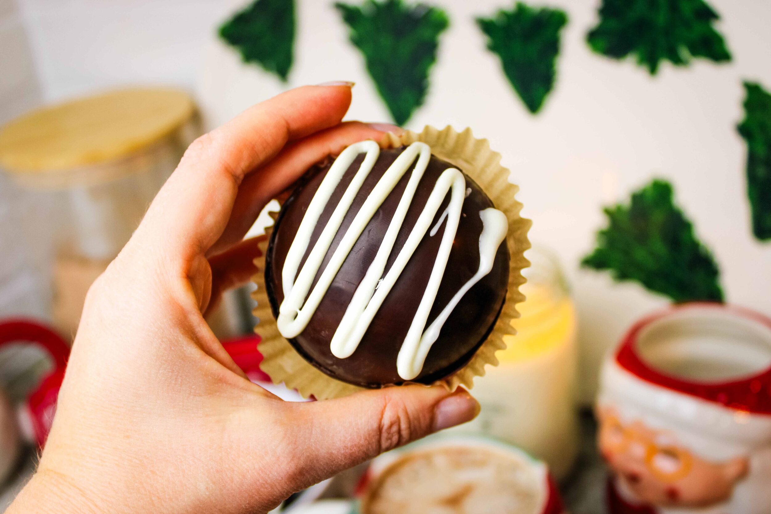 Close up of a hand holding a healthier hot chocolate bomb.